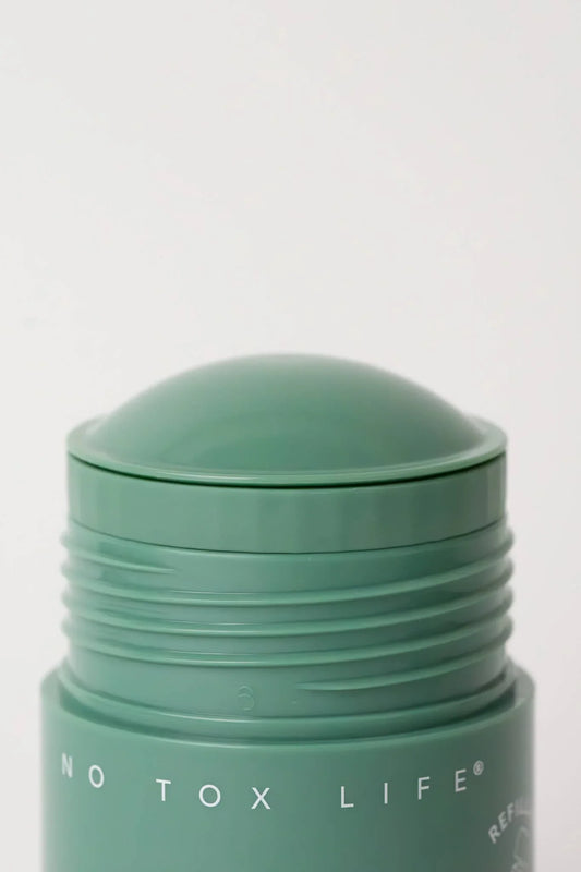 Green No Tox Life deodorant stick with rounded cap, minimalist design. Come see us at Awaken, Franklin, Tennessee