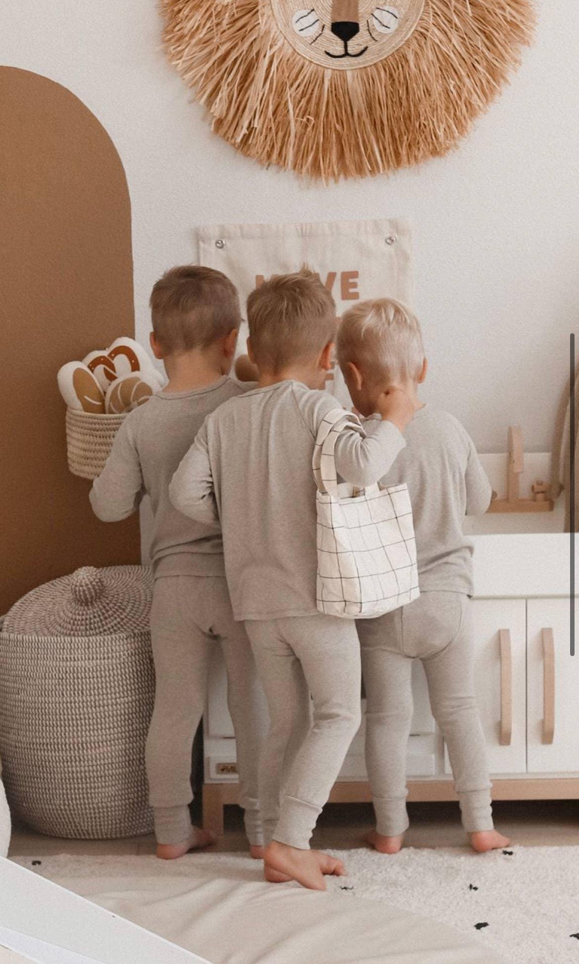 Three young children in matching beige pajamas in a cozy playroom, Come see us at Awaken, Franklin, Tennessee
