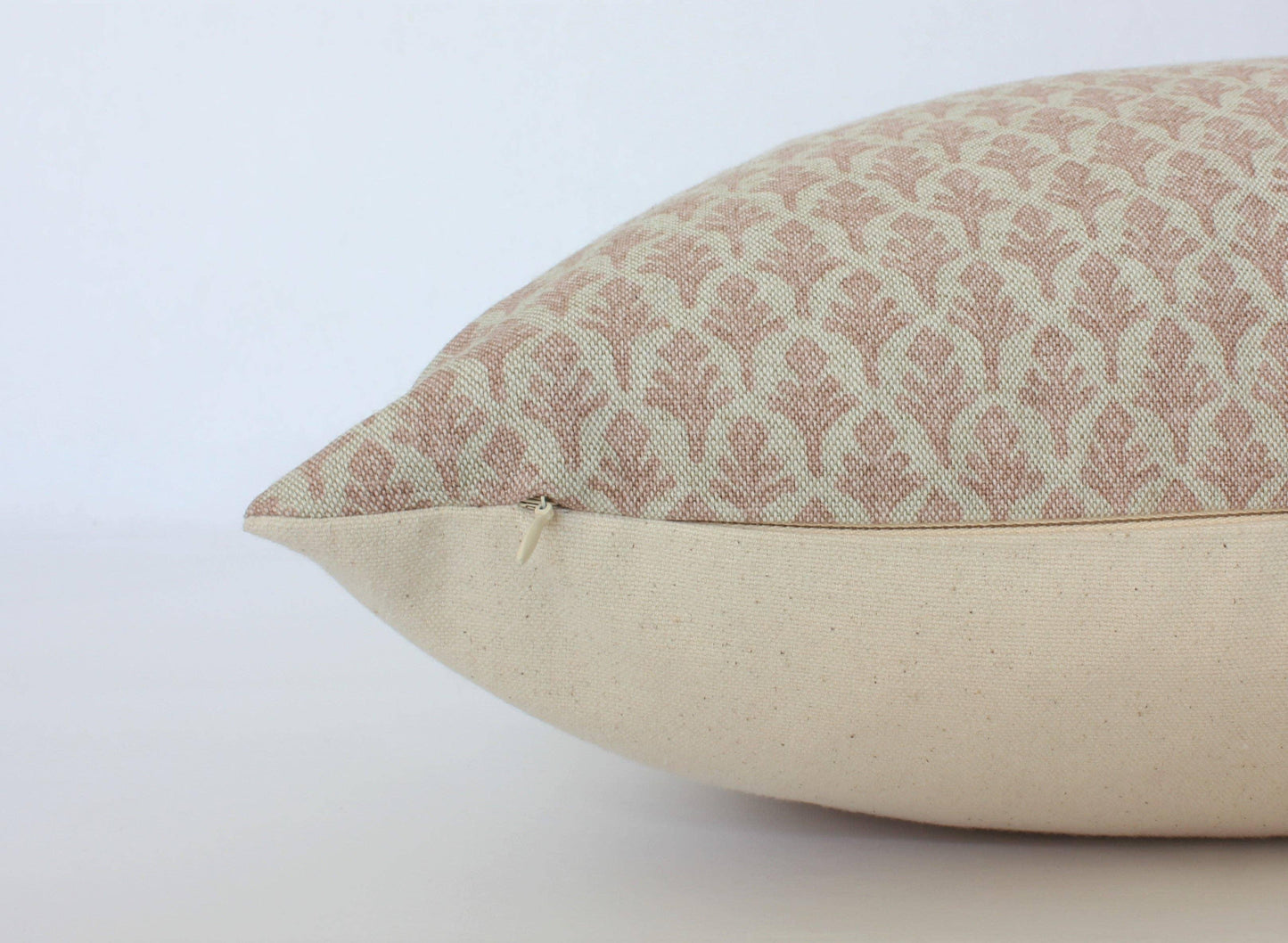 Beige and light brown decorative pillow with floral pattern and zipper detail on plain background, Come see us at Awaken, Franklin, Tennessee