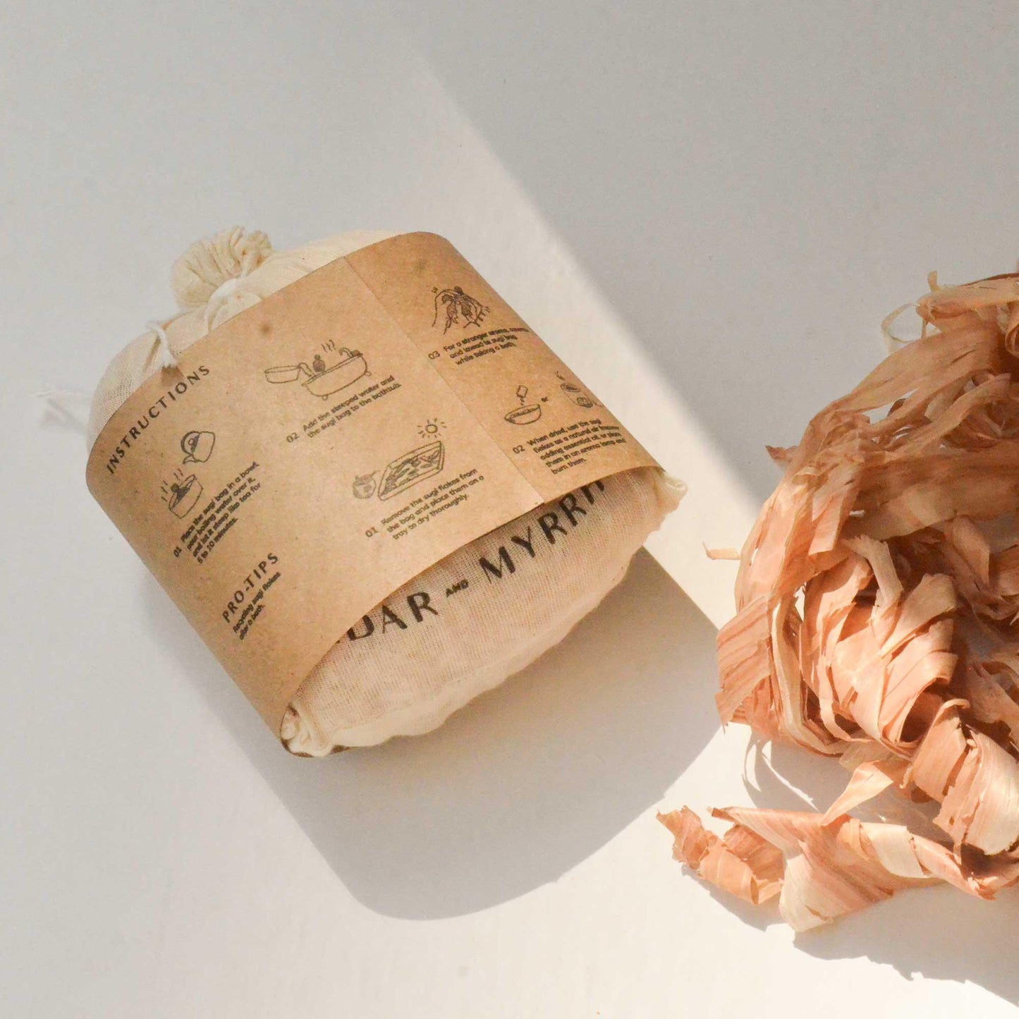 Bundle of cedar and myrrh wood shavings with instructions label in natural light; Come see us at Awaken, Franklin, Tennessee