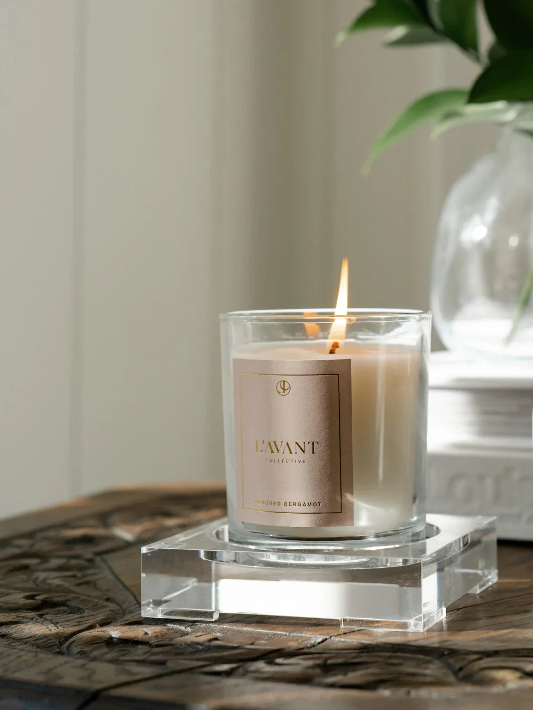 Lavant Collective Brushed Bergamot candle burning on wooden table, cozy decor. Come see us at Awaken, Franklin, Tennessee