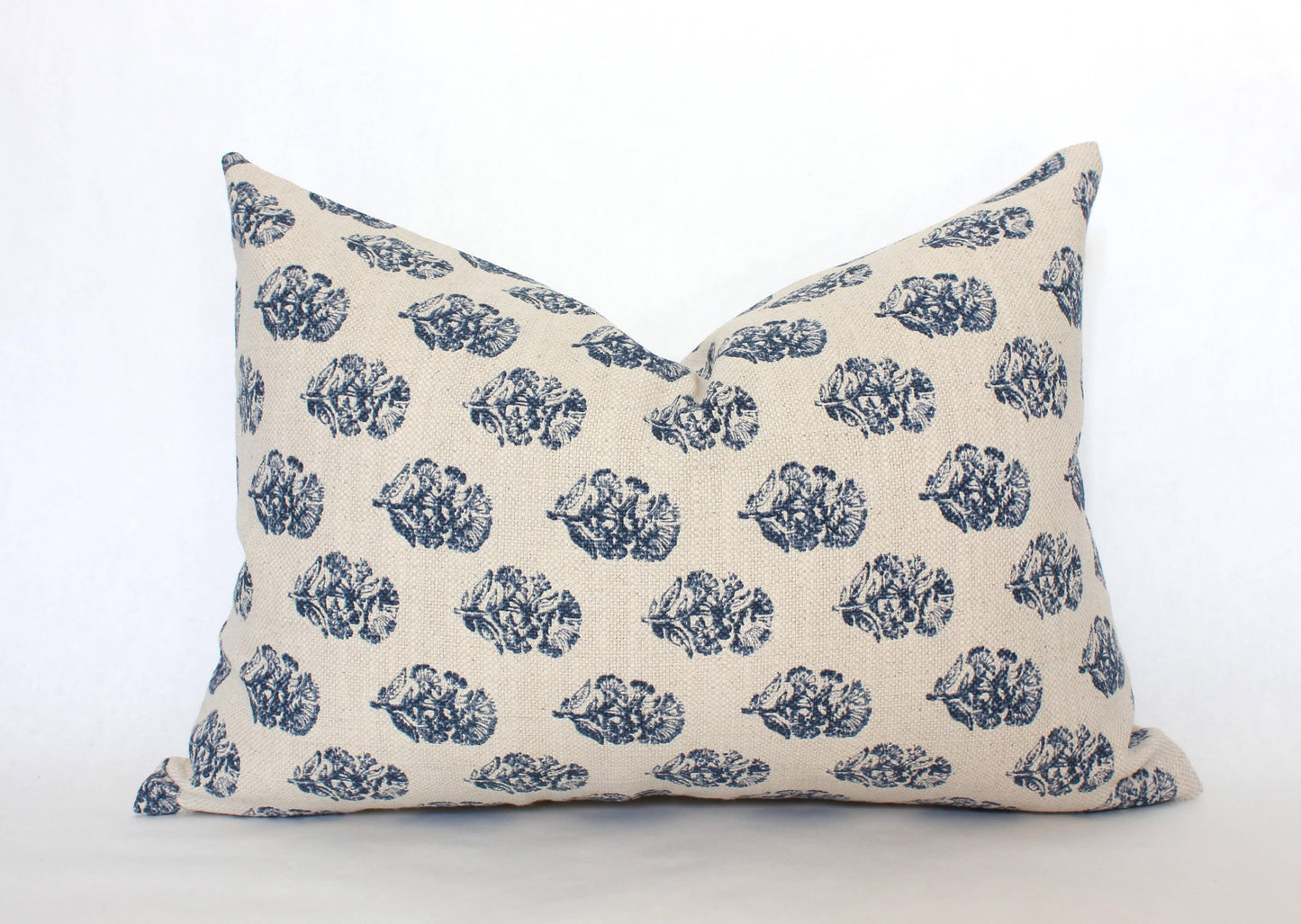Decorative beige pillow with blue leaf pattern on white background. Come see us at Awaken, Franklin, Tennessee
