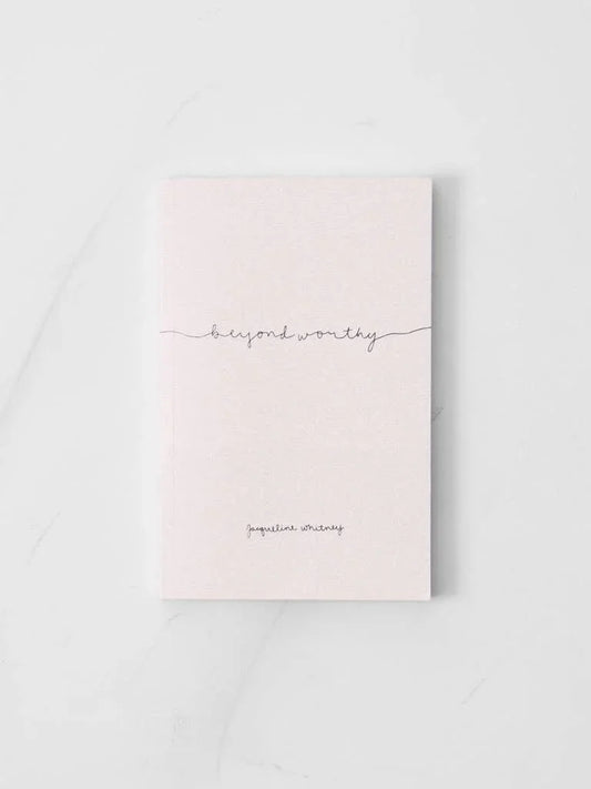 Minimalist pale pink book titled beyond worthy by Jacqueline Whitney on white surface. Come see us at Awaken, Franklin, Tennessee