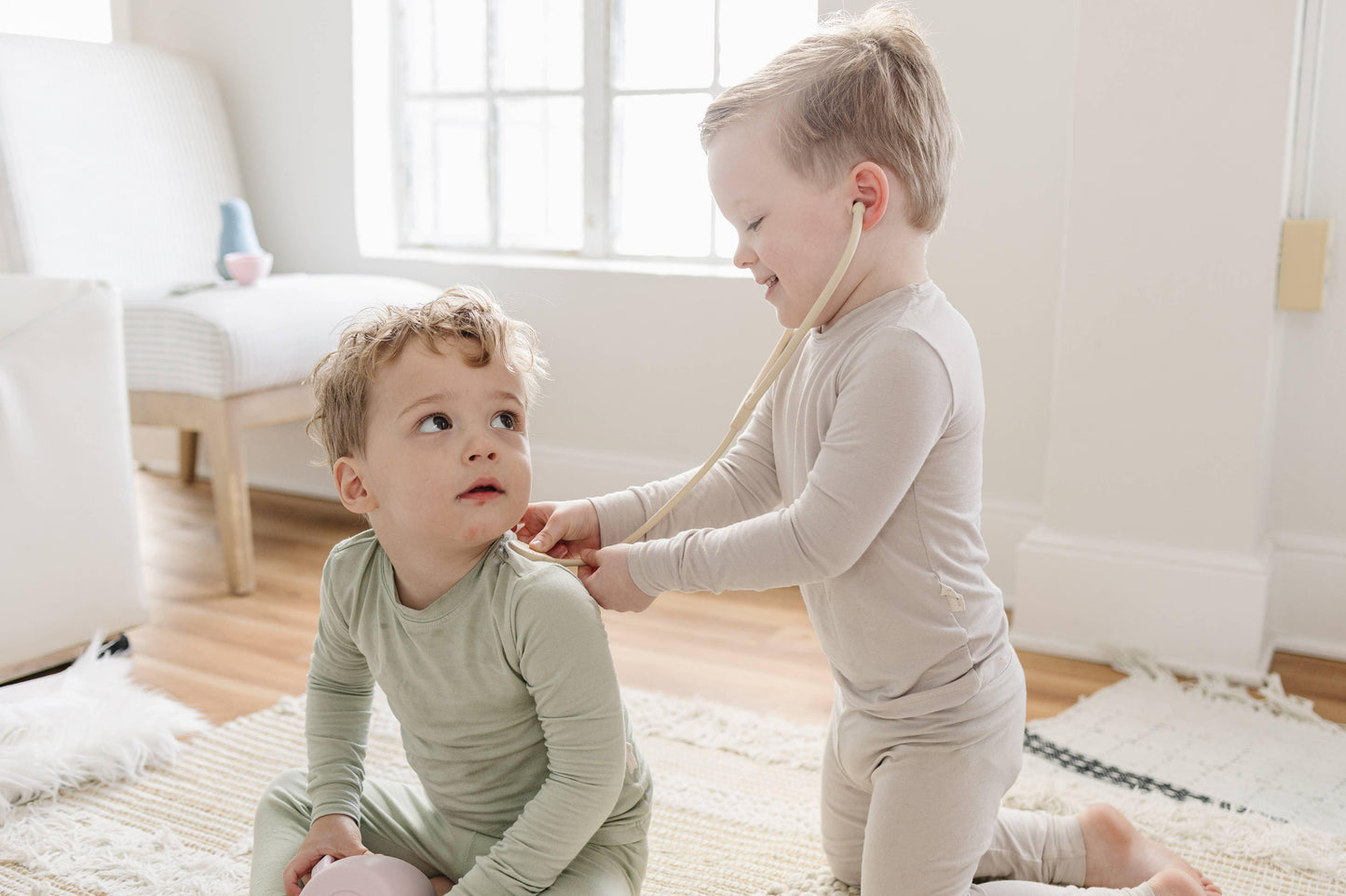 Two young boys playing doctor with a stethoscope in a bright living room, Come see us at Awaken, Franklin, Tennessee