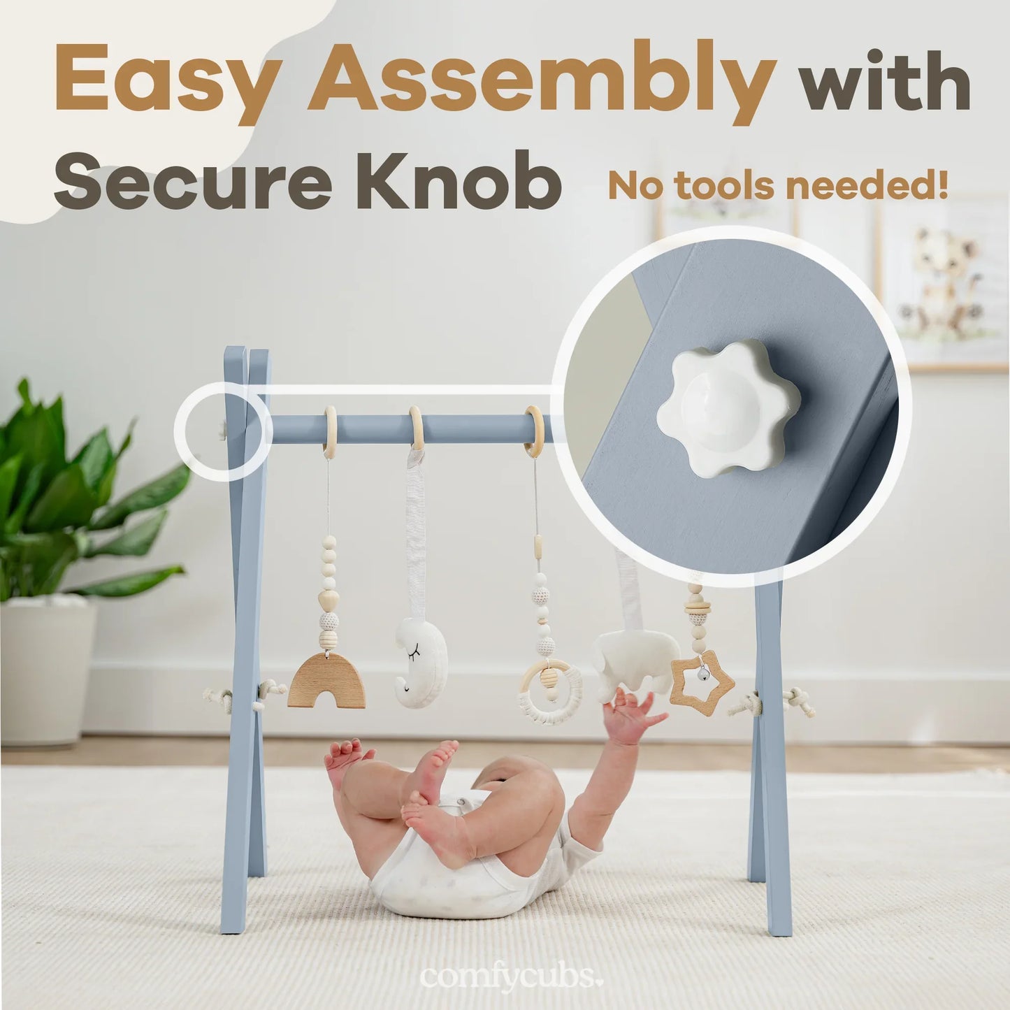 Baby playing with blue wooden gym featuring hanging toys and secure knob. Come see us at Awaken, Franklin, Tennessee