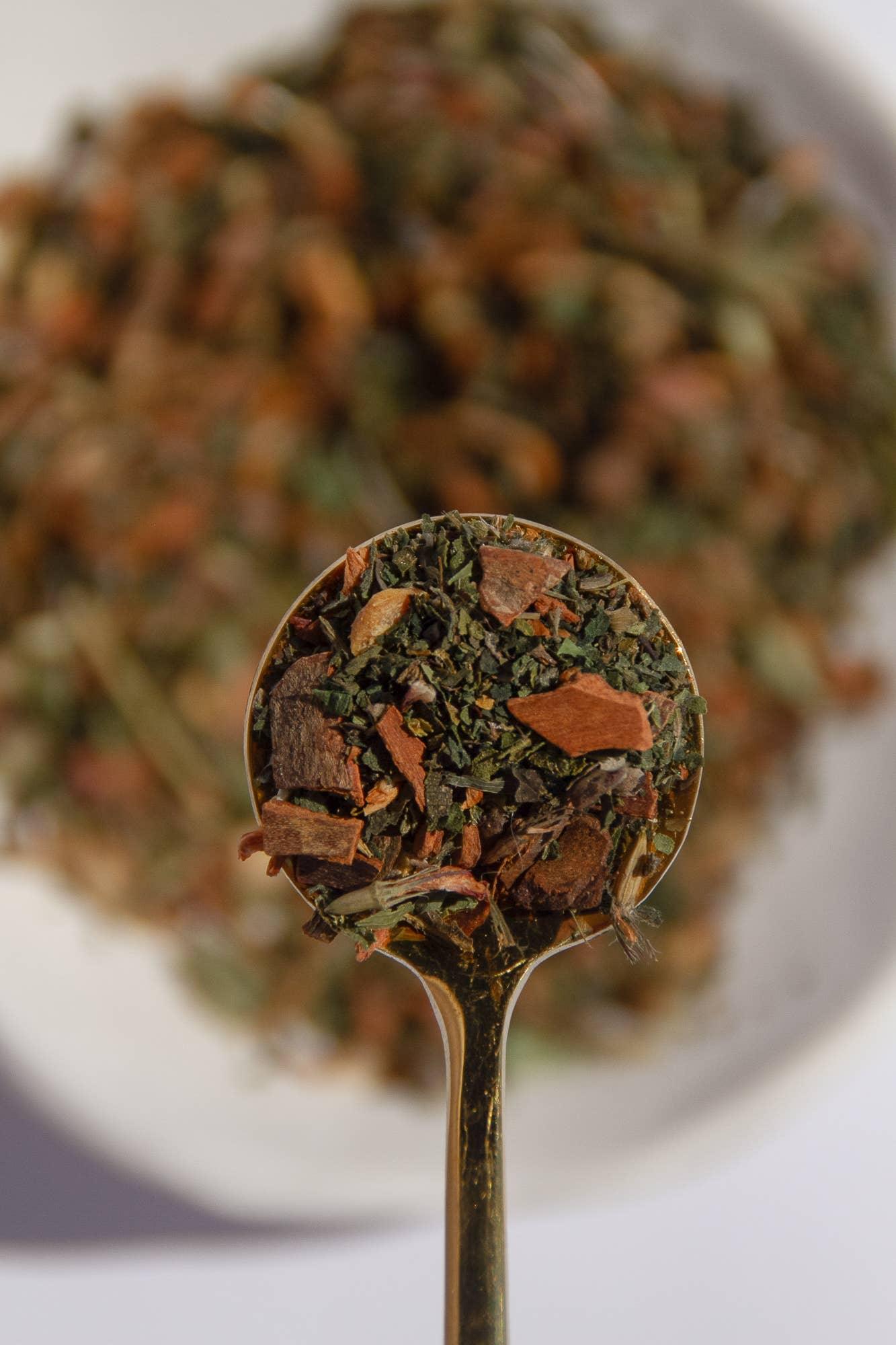 Close-up of mixed herbs and spices in a golden spoon with a blurred bowl background. Come see us at Awaken, Franklin, Tennessee