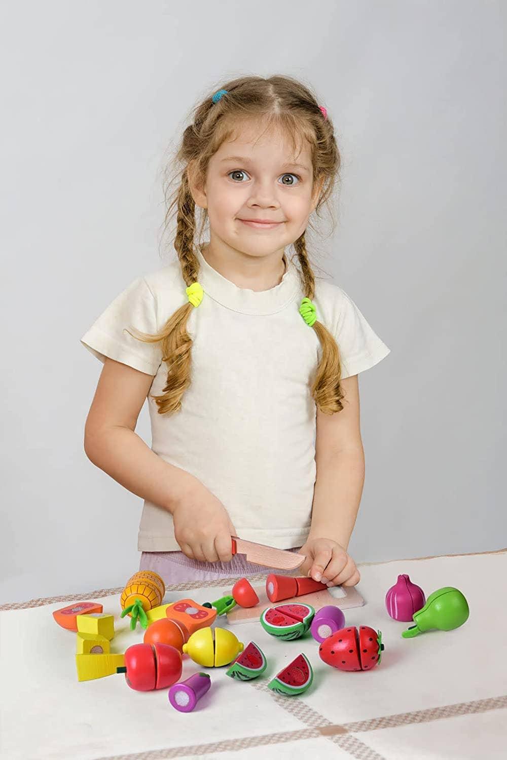 Smiling girl with braids playing with wooden toy fruits, Come see us at Awaken, Franklin, Tennessee.