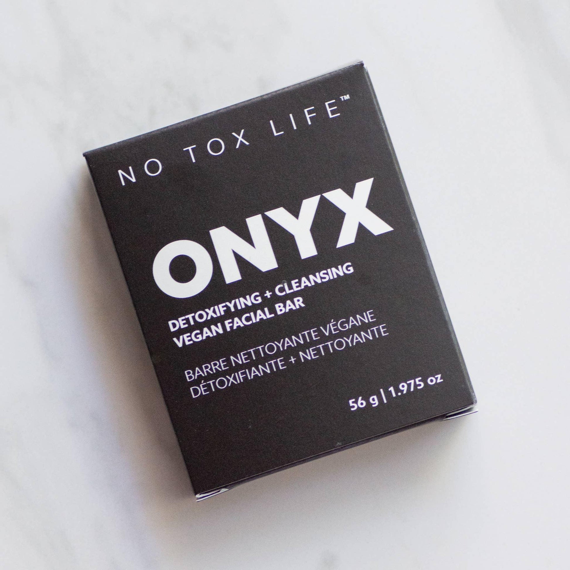 ONYX vegan facial bar for detoxifying and cleansing in black packaging on marble surface. Come see us at Awaken, Franklin, Tennessee