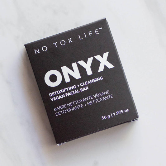 ONYX vegan facial bar for detoxifying and cleansing in black packaging on marble surface. Come see us at Awaken, Franklin, Tennessee