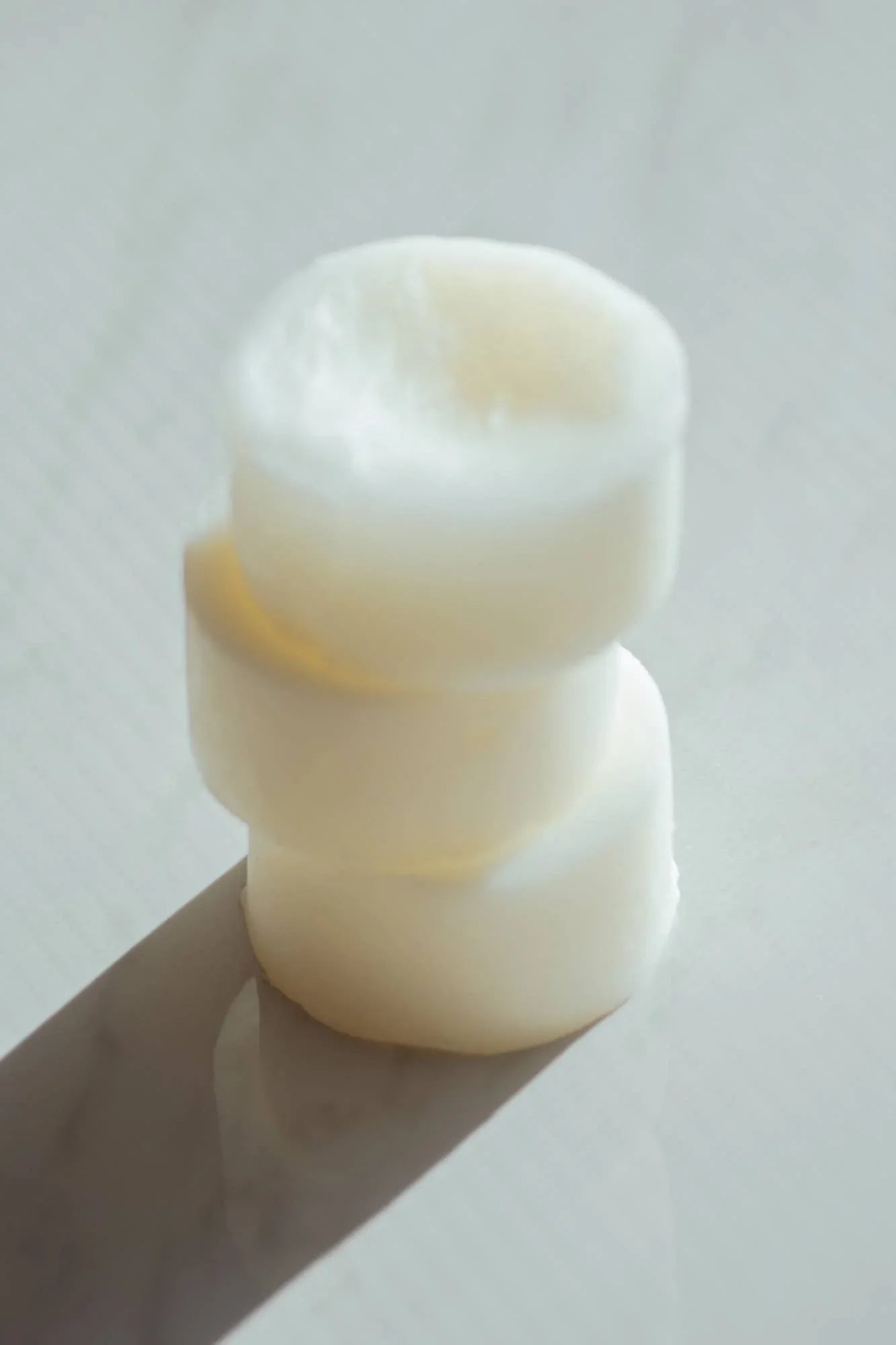 Stacked white wax melts on a light surface in soft lighting. Come see us at Awaken, Franklin, Tennessee