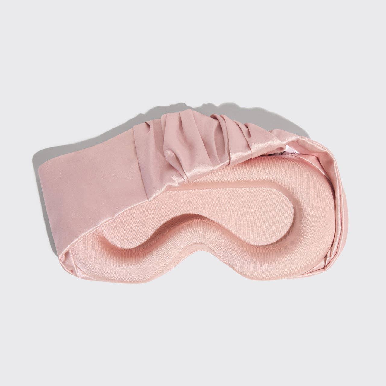 Pink satin sleep mask with contoured eye spaces on white background. Come see us at Awaken, Franklin, Tennessee