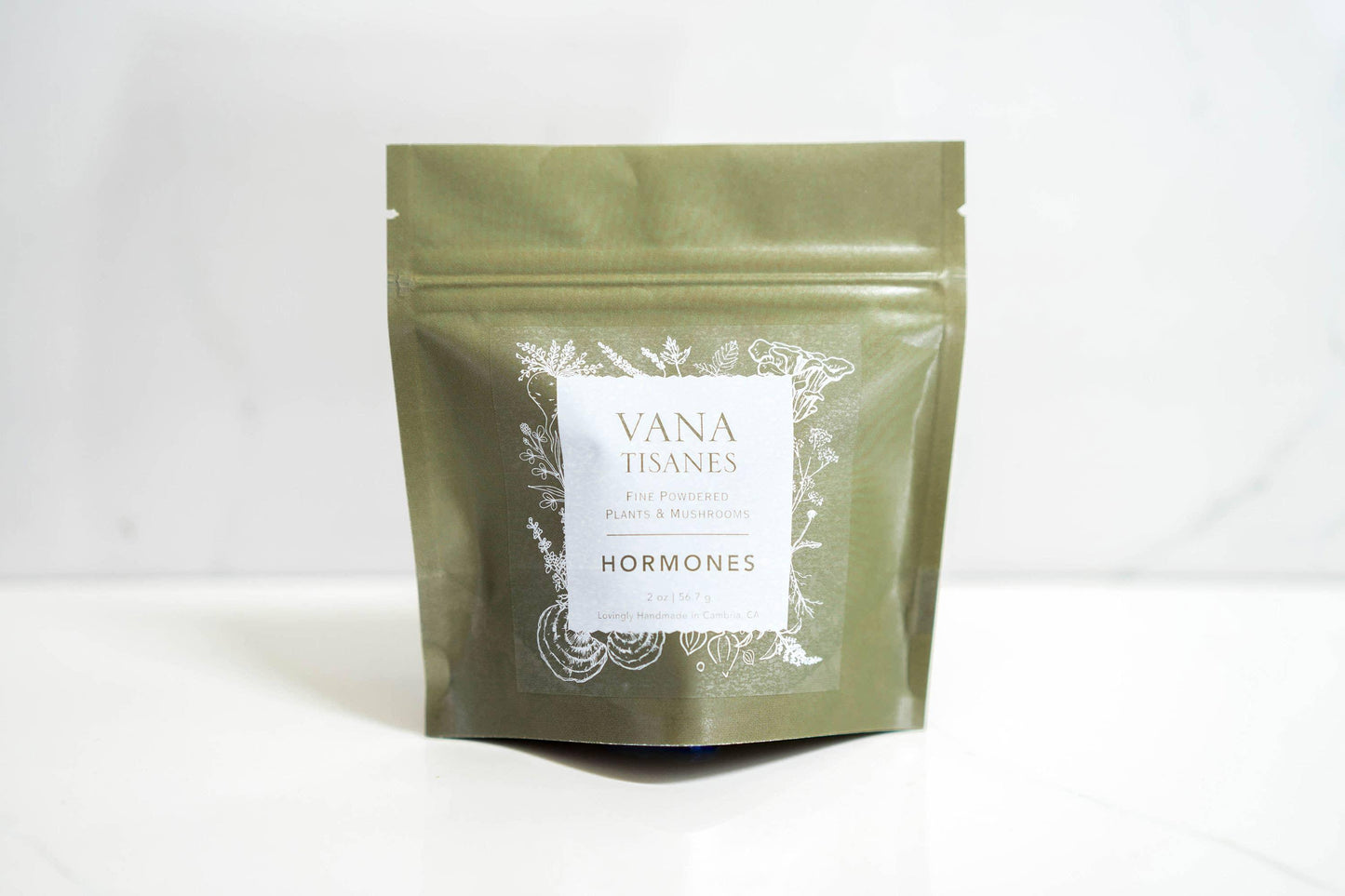 Green package of Vana Tisanes fine powdered plants and mushrooms labeled Hormones on white surface. Come see us at Awaken, Franklin, Tennessee