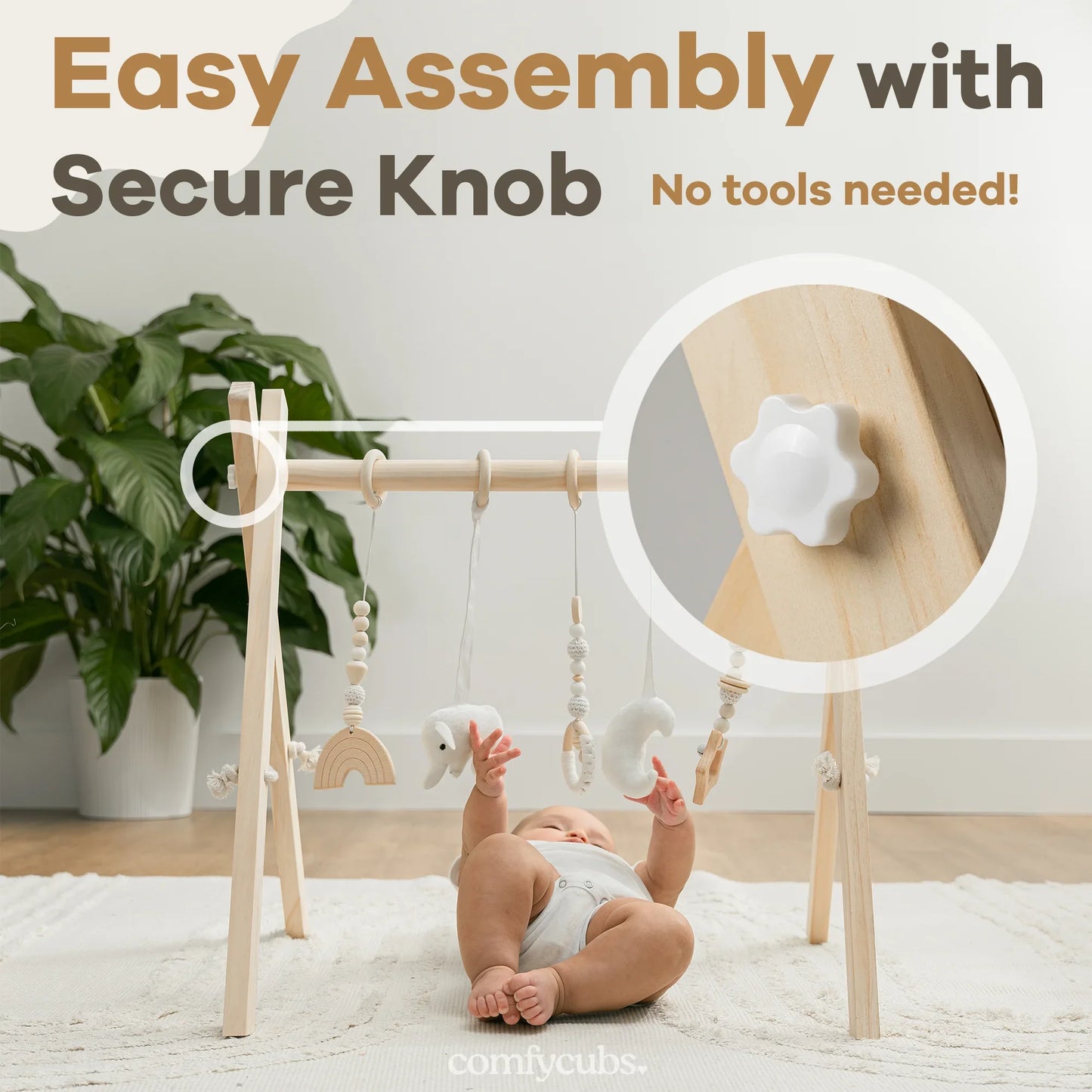 Baby playing with wooden baby gym featuring hanging toys and secure knob, easy assembly. Come see us at Awaken, Franklin, Tennessee