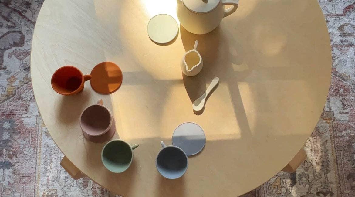 Colorful ceramic cups and teapot on round wooden table in sunlight, Come see us at Awaken, Franklin, Tennessee