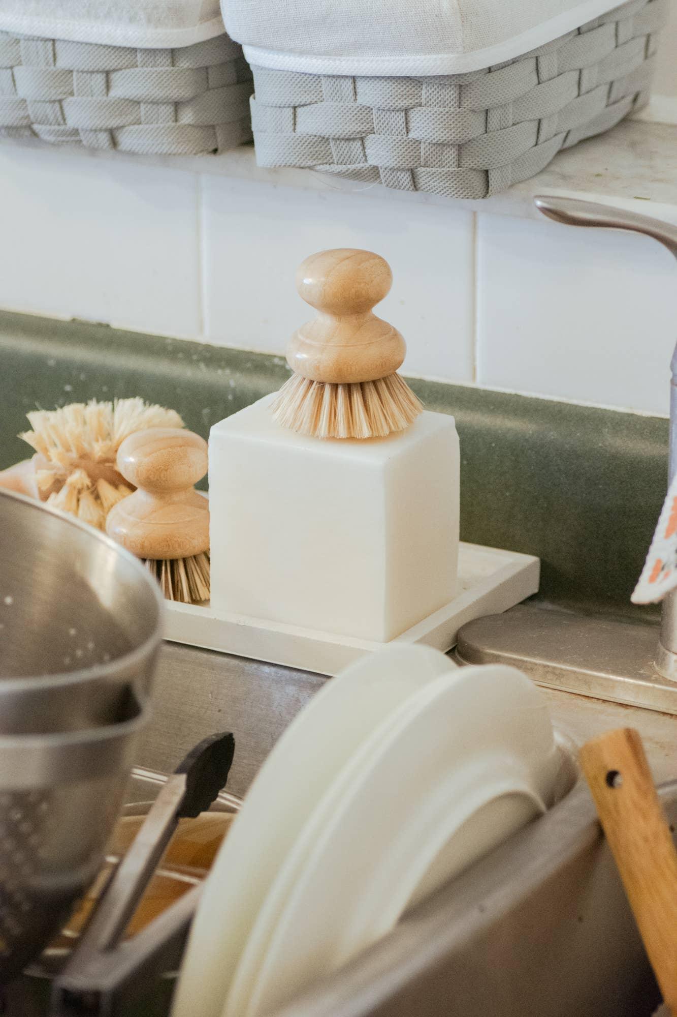 Wooden dish brushes and block soap by kitchen sink with clean dishes Come see us at Awaken, Franklin, Tennessee