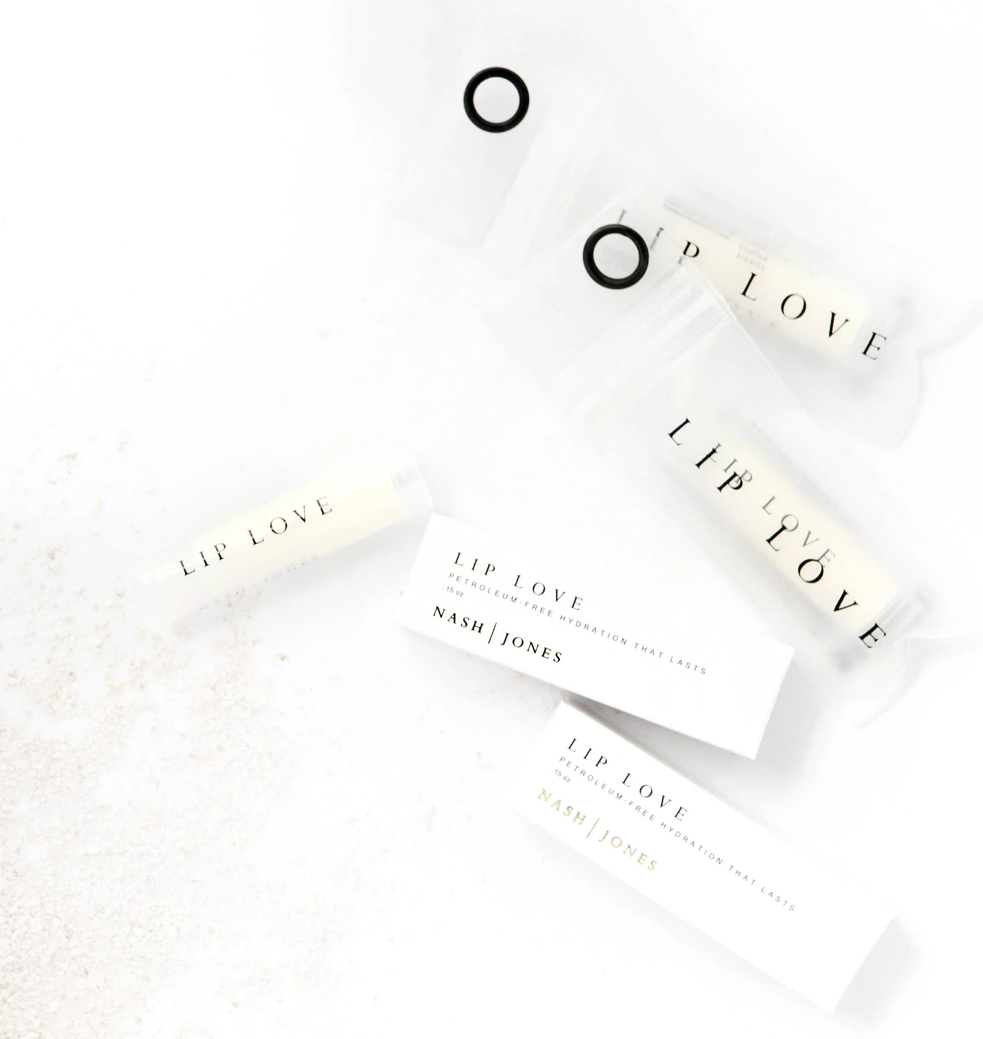 Lip Love petroleum-free lip balms and packaging by Nash Jones displayed on white surface. Come see us at Awaken, Franklin, Tennessee