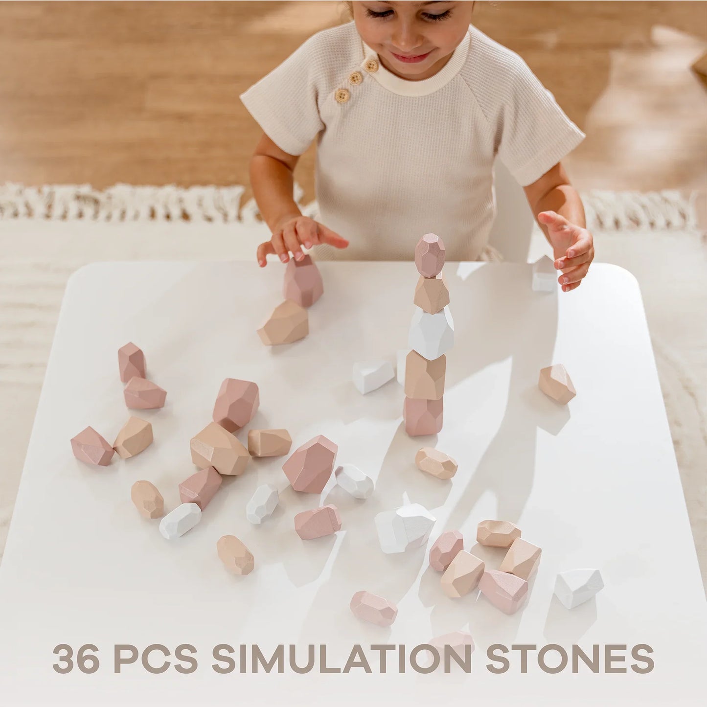 Child playing with 36 pcs simulation stones toy on a white table, stacking colorful blocks. Come see us at Awaken, Franklin, Tennessee
