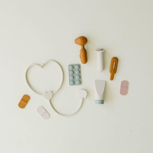 Children's medical toy set with stethoscope, syringe, pills, and bandages on white background. Come see us at Awaken, Franklin, Tennessee
