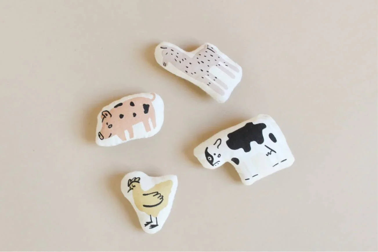 Handmade fabric farm animal toys—pig, llama, cow, chicken on beige. Come see us at Awaken, Franklin, Tennessee.