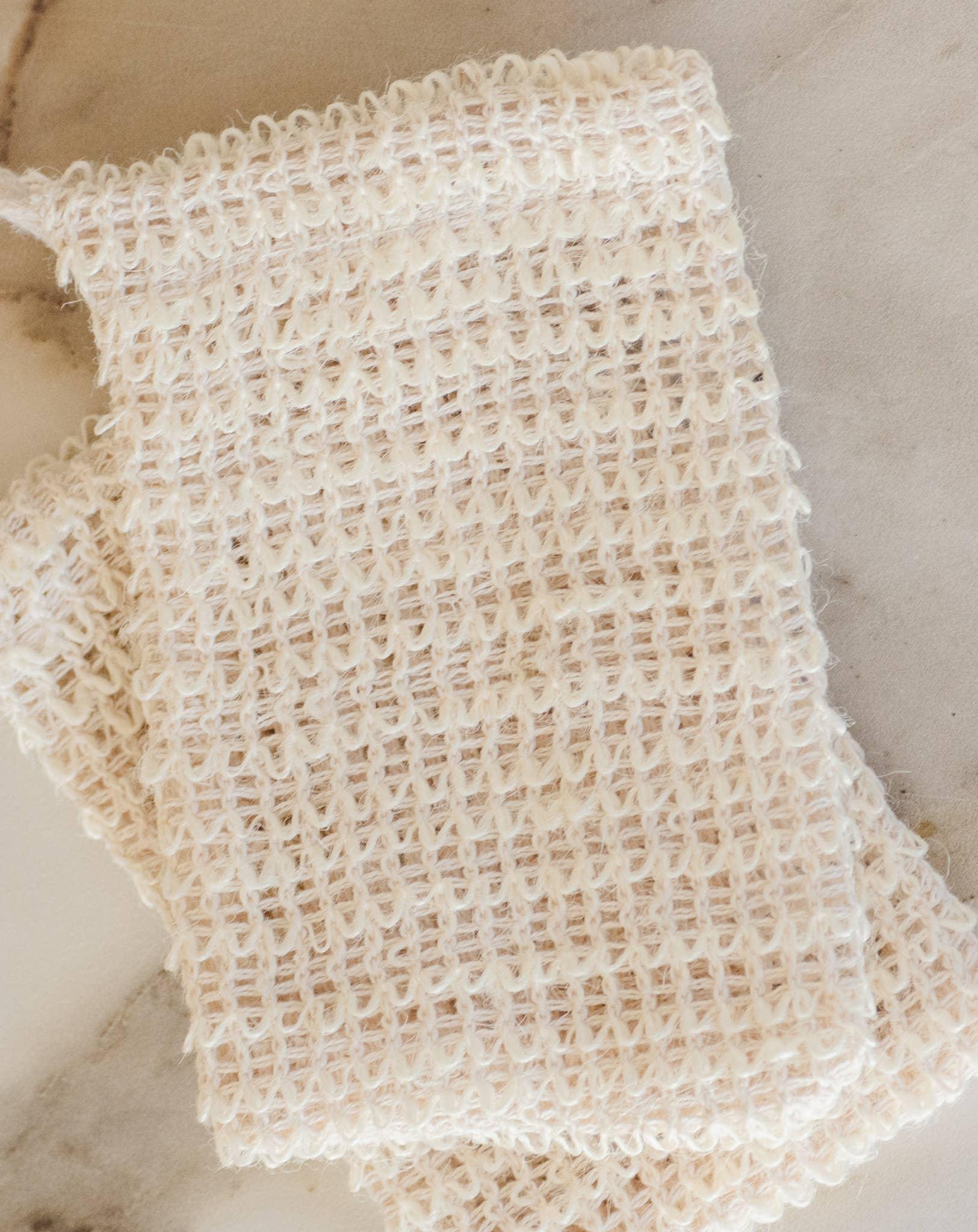 Close-up of a beige knitted fabric piece on a marble surface. Come see us at Awaken, Franklin, Tennessee