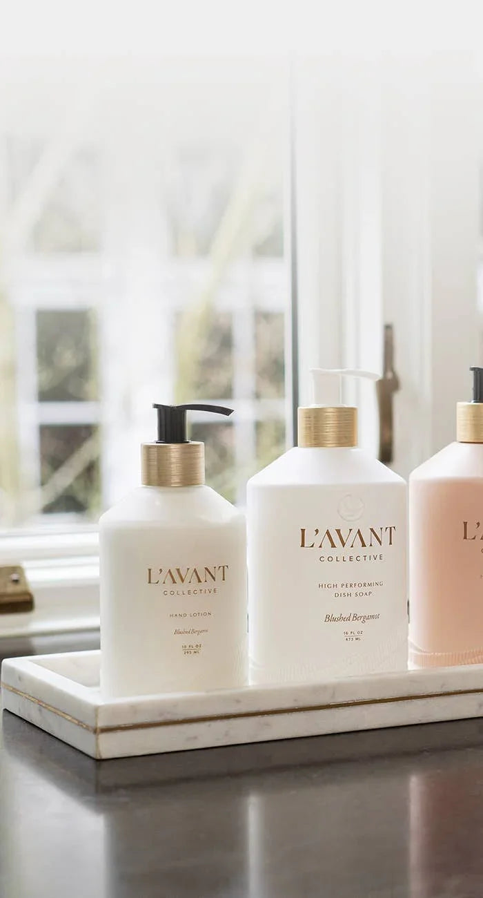 L’AVANT Collective hand lotion and dish soap by a window in a tray. Come see us at Awaken, Franklin, Tennessee