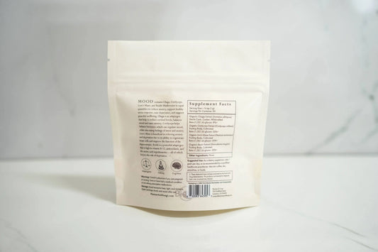 Back of white supplement pouch labeled MOOD with ingredients and supplement facts on marble surface. Come see us at Awaken, Franklin, Tennessee