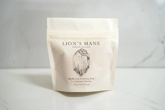 Lion's Mane mushroom fruiting body extract powder in white pouch on marble surface, Come see us at Awaken, Franklin, Tennessee