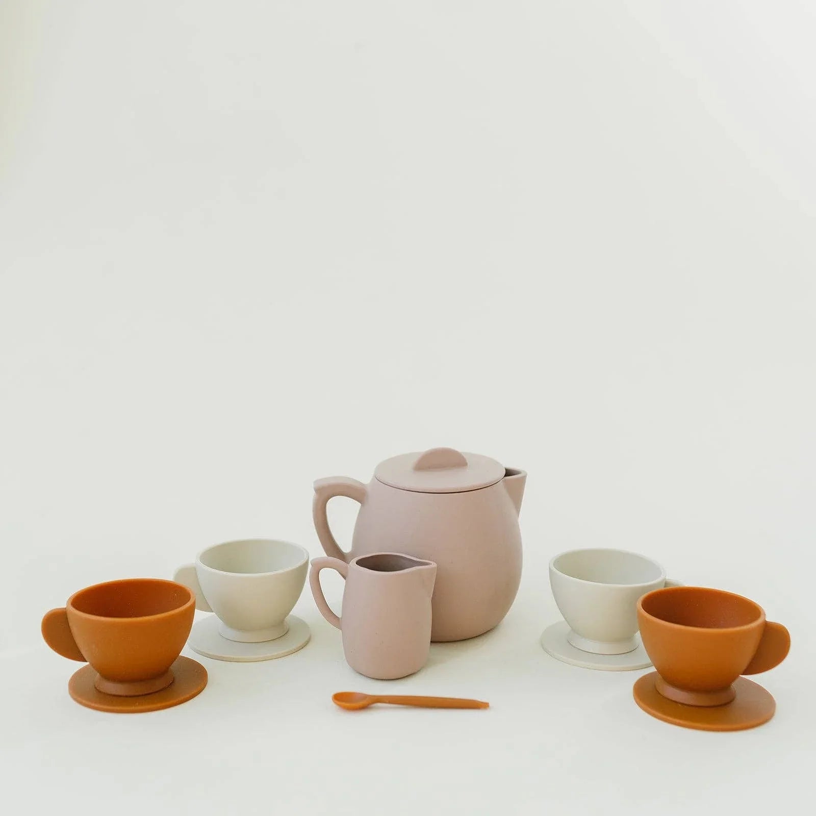Minimalist tea set with pink teapot, cups, saucers, and spoon. Come see us at Awaken, Franklin, Tennessee.