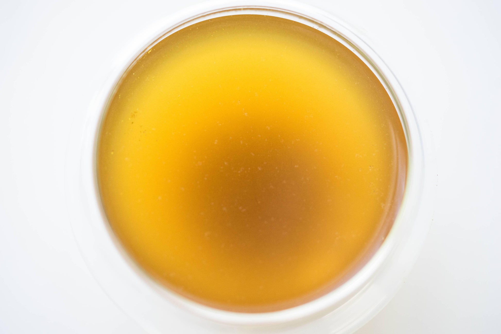 Close-up of a glass filled with golden liquid, likely tea or cider. Come see us at Awaken, Franklin, Tennessee