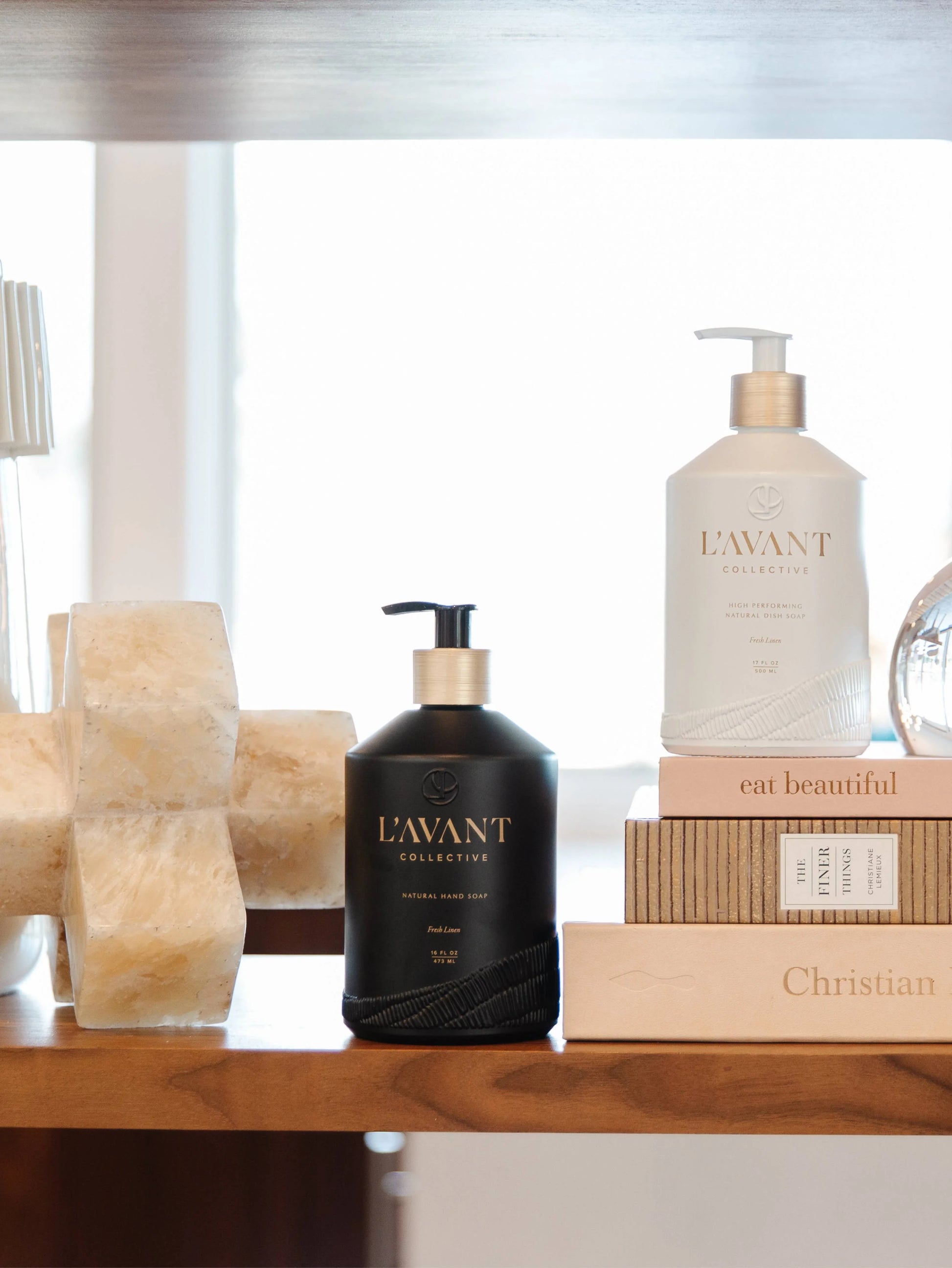 L'AVANT Collective hand soap and dish soap on a shelf with books, Come see us at Awaken, Franklin, Tennessee