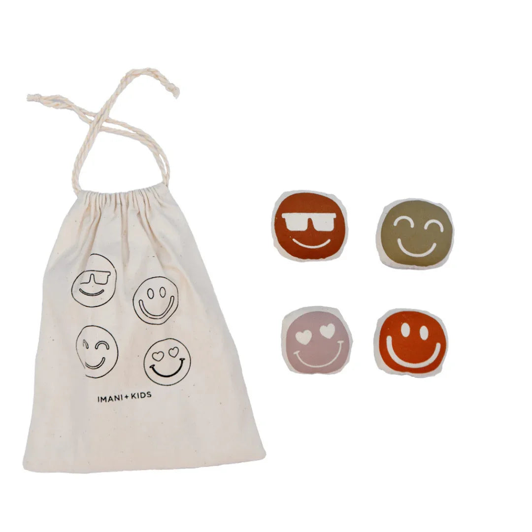 Imani + Kids drawstring bag with four colorful smiley face toys, Come see us at Awaken, Franklin, Tennessee