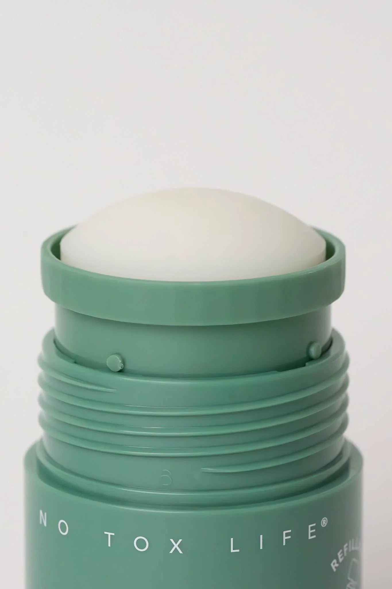 Close-up of green No Tox Life solid deodorant stick on white background. Come see us at Awaken, Franklin, Tennessee
