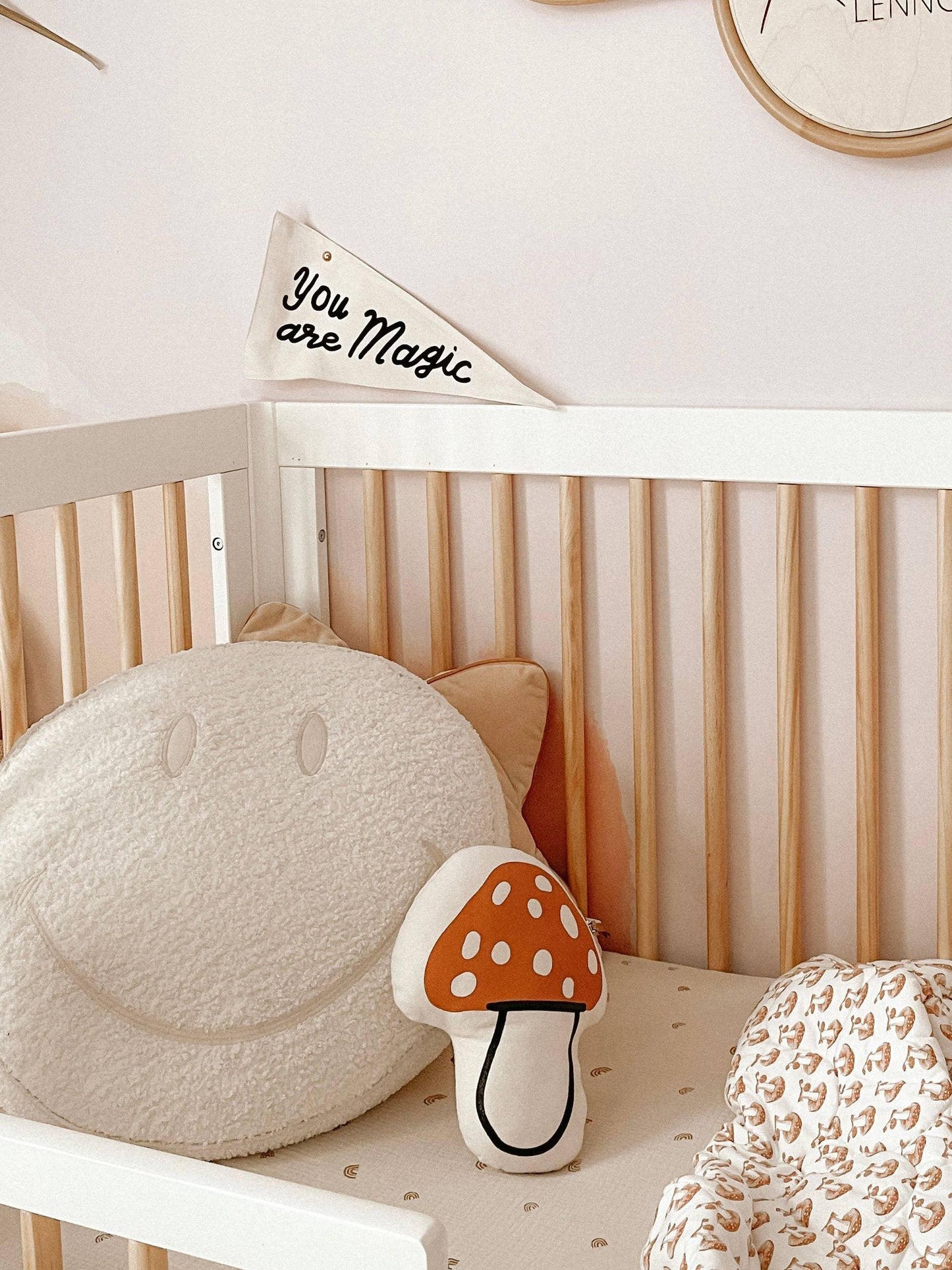 Cozy nursery crib with smiley face and mushroom pillows, You are Magic banner, Come see us at Awaken, Franklin, Tennessee