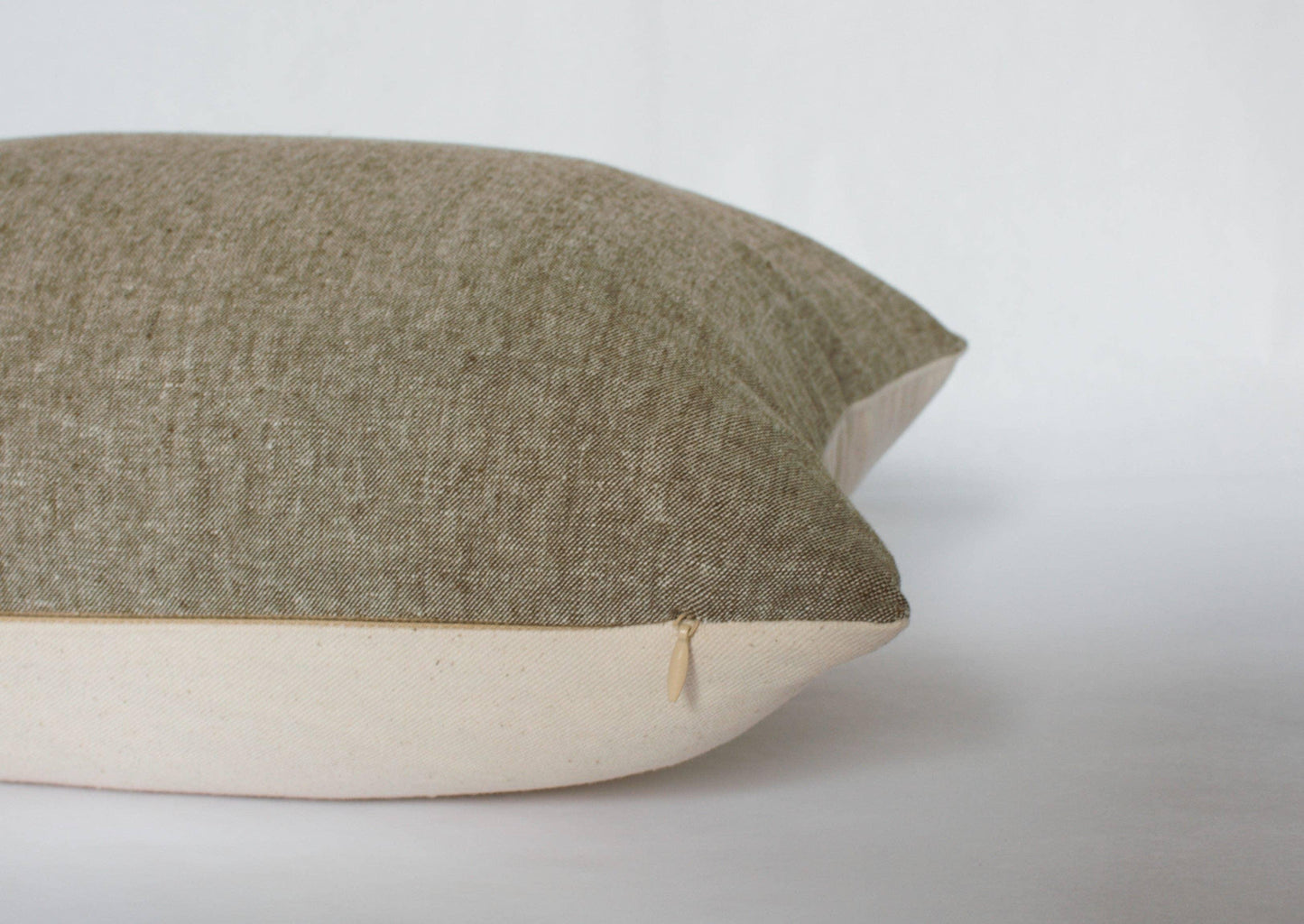 Beige and brown two-tone textured pillow with zipper detail on white background. Come see us at Awaken, Franklin, Tennessee