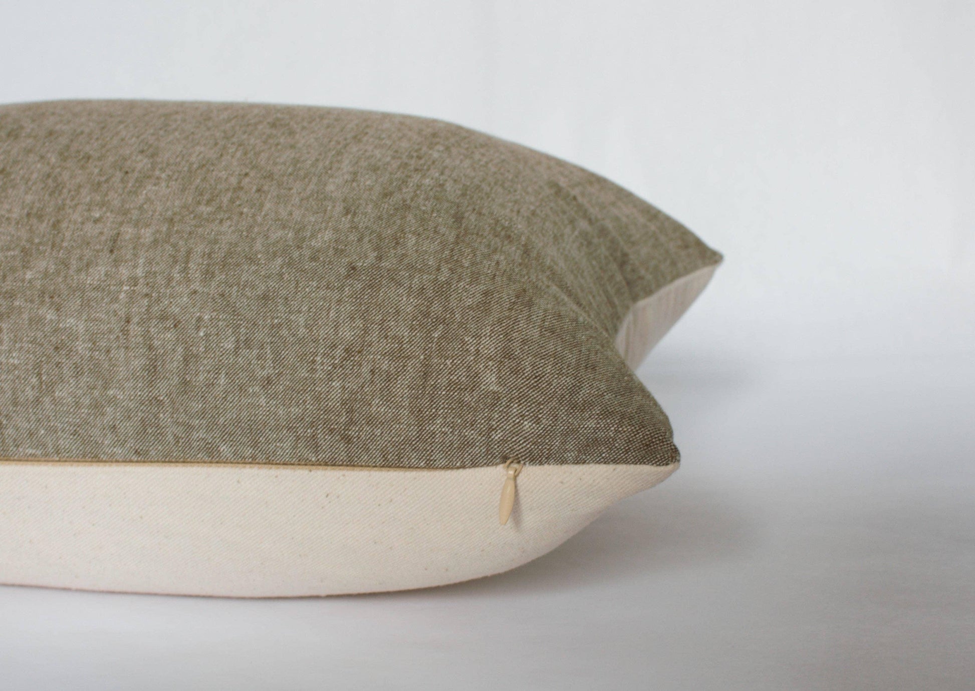 Beige and brown two-tone textured pillow with zipper detail on white background. Come see us at Awaken, Franklin, Tennessee