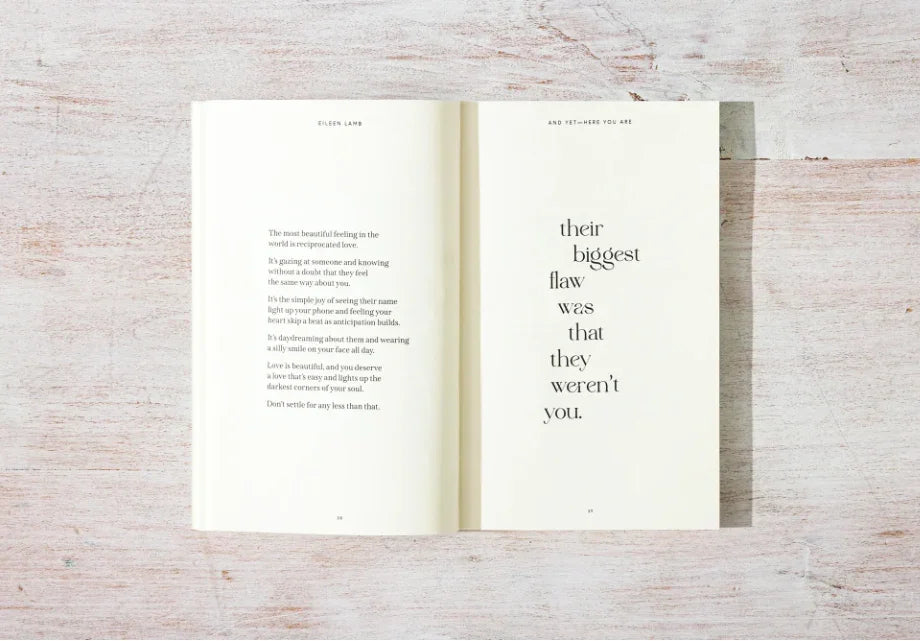 Open poetry book by Eileen Lamb on rustic wood surface, featuring love-themed quotes, Come see us at Awaken, Franklin, Tennessee