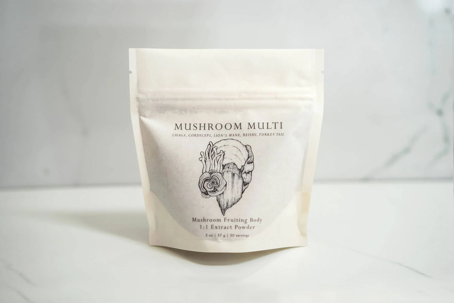 Mushroom Multi extract powder package on white marble surface with sketch art, Come see us at Awaken, Franklin, Tennessee