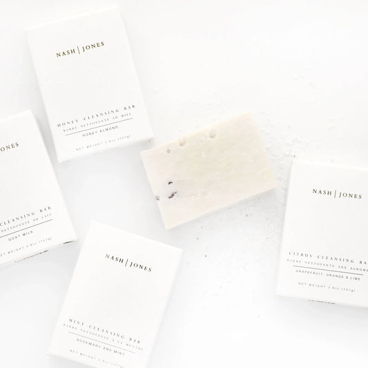 Nash Jones cleansing bars in minimalist white packaging with one bar unwrapped, clean aesthetic, Come see us at Awaken, Franklin, Tennessee