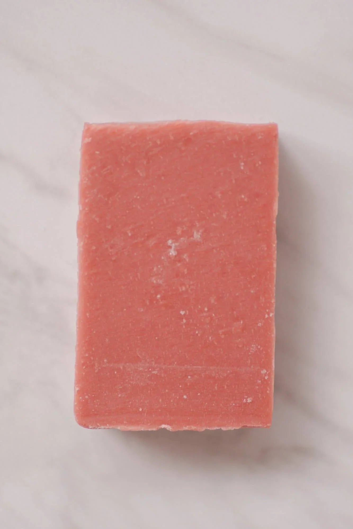 Rectangular pink soap bar on white marble surface, natural skincare product. Come see us at Awaken, Franklin, Tennessee