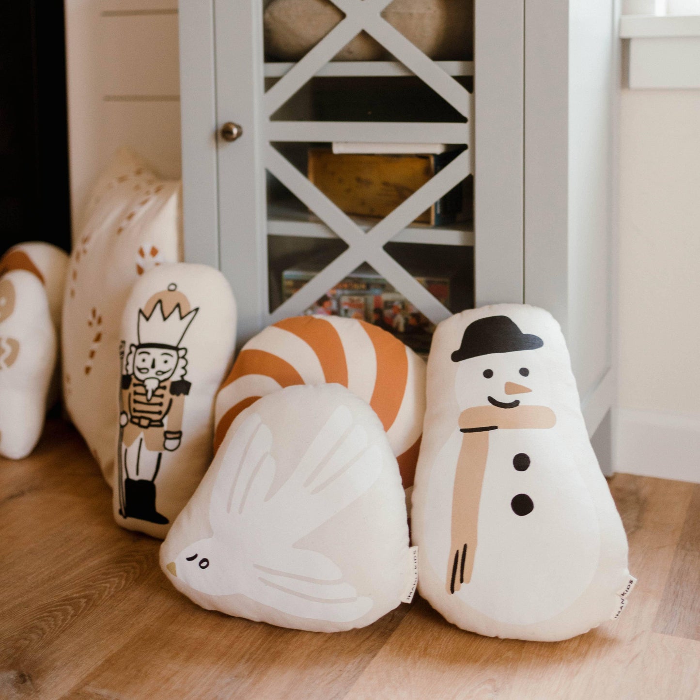 Holiday decorative pillows with snowman, nutcracker, bird and peppermint in cozy room. Come see us at Awaken, Franklin, Tennessee