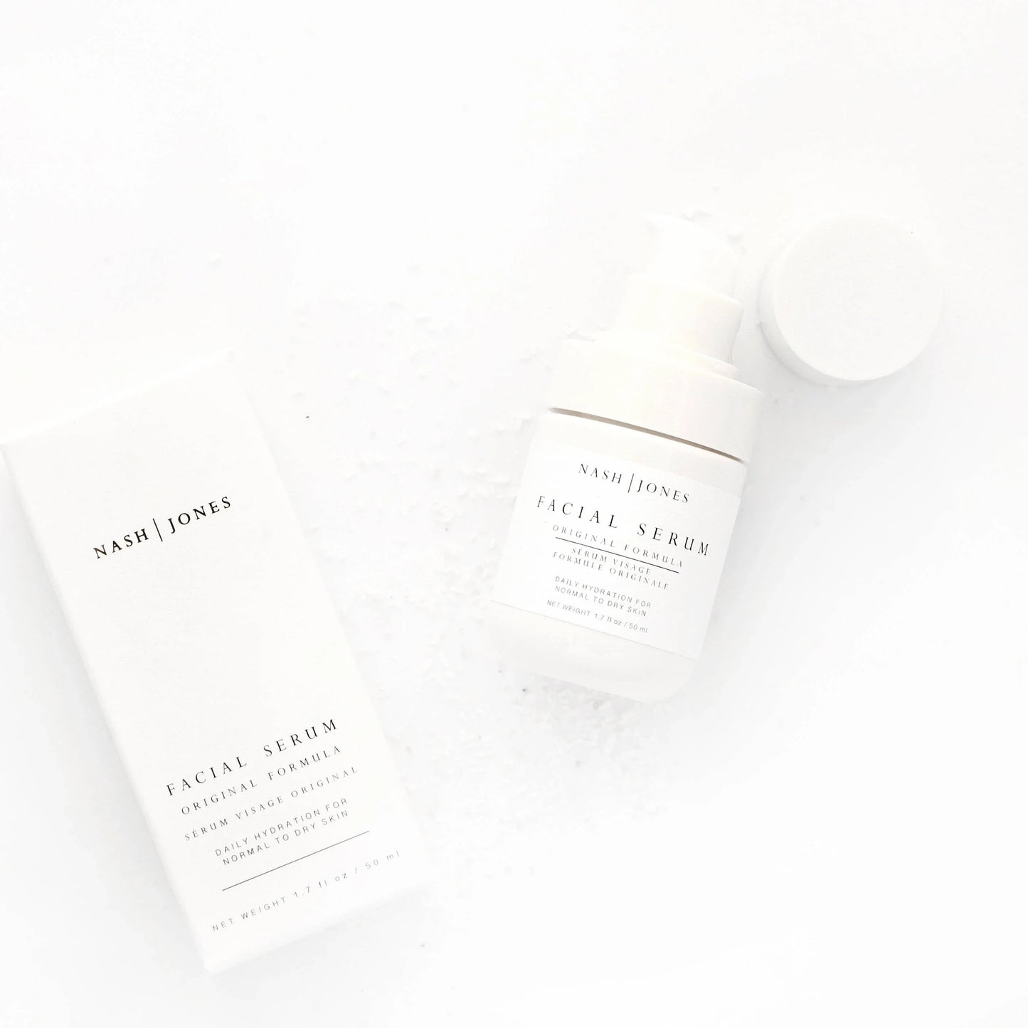 Nash | Jones facial serum bottle and box on white background with sea salt flakes, skincare product. Come see us at Awaken, Franklin, Tennessee