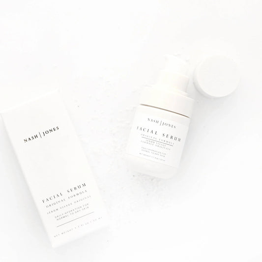 Nash | Jones facial serum bottle and box on white background with sea salt flakes, skincare product. Come see us at Awaken, Franklin, Tennessee