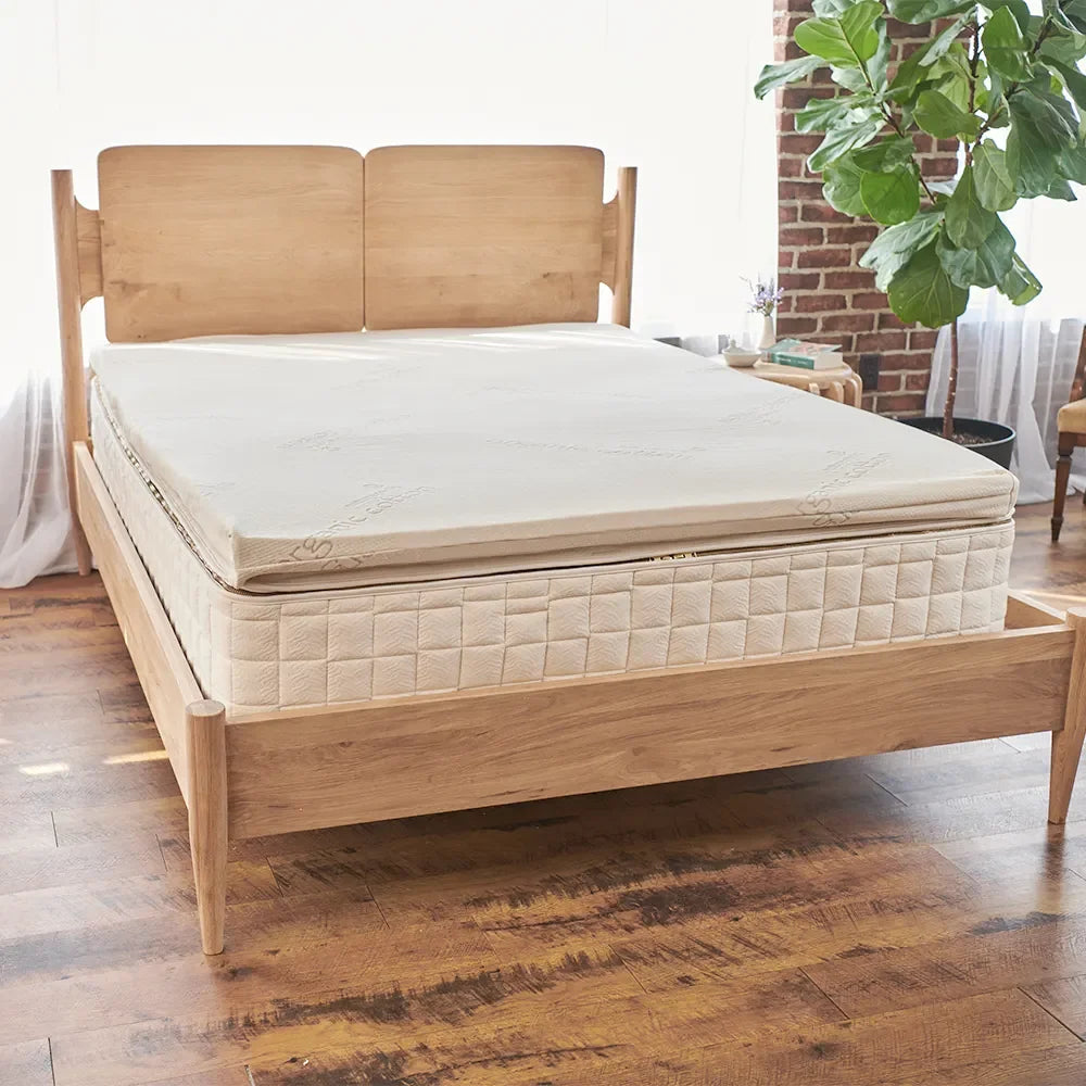 Natural wood bed frame with organic mattress in bright bedroom, Come see us at Awaken, Franklin, Tennessee
