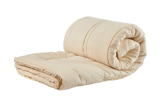 Rolled beige cotton futon mattress with thick padding on white background. Come see us at Awaken, Franklin, Tennessee