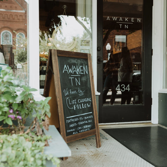 Awaken TN store entrance with chalkboard sign advertising life-changing pillow and organic products. Come see us at Awaken, Franklin, Tennessee